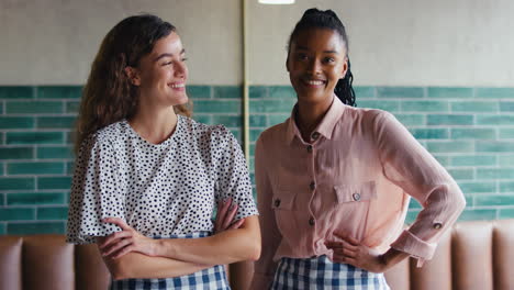 retrato de dos dueñas sonrientes o empleados que trabajan en una cafetería o cafetería