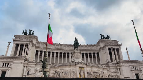 tilt down shot of italian altar of the fatherland with flag against cloudy sky in rome,italy