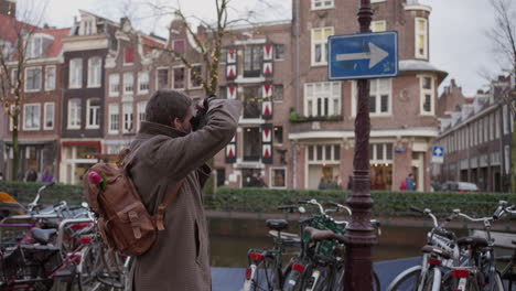 hipster tourist capturing amsterdam's canal essence. netherlands travel