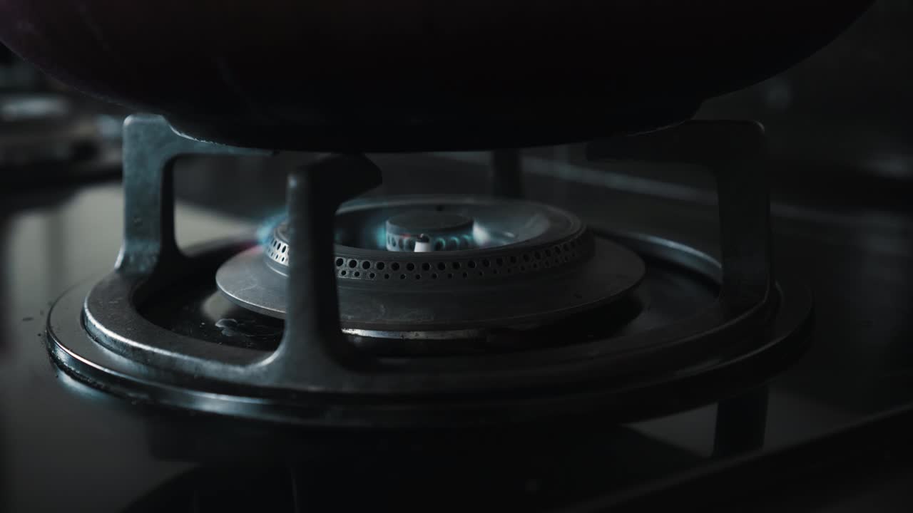 부에서 파란색과 빨간색으로 불타는 불꽃이 있는 검은색 가스 스토브의 비디오