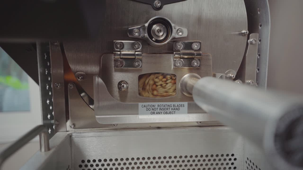 Processamento de grãos de café em máquina de torrefação com pequena janela, timelapse estático