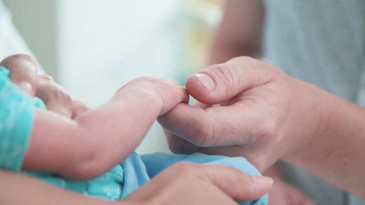 신생아 의 손 을 만지는 아버지 의 근접 사진