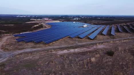 Impressive-aerial-orbit-over-solar-panel-and-energy-storage-farm-with-a-scenic-view-over-farmland-in-Greece