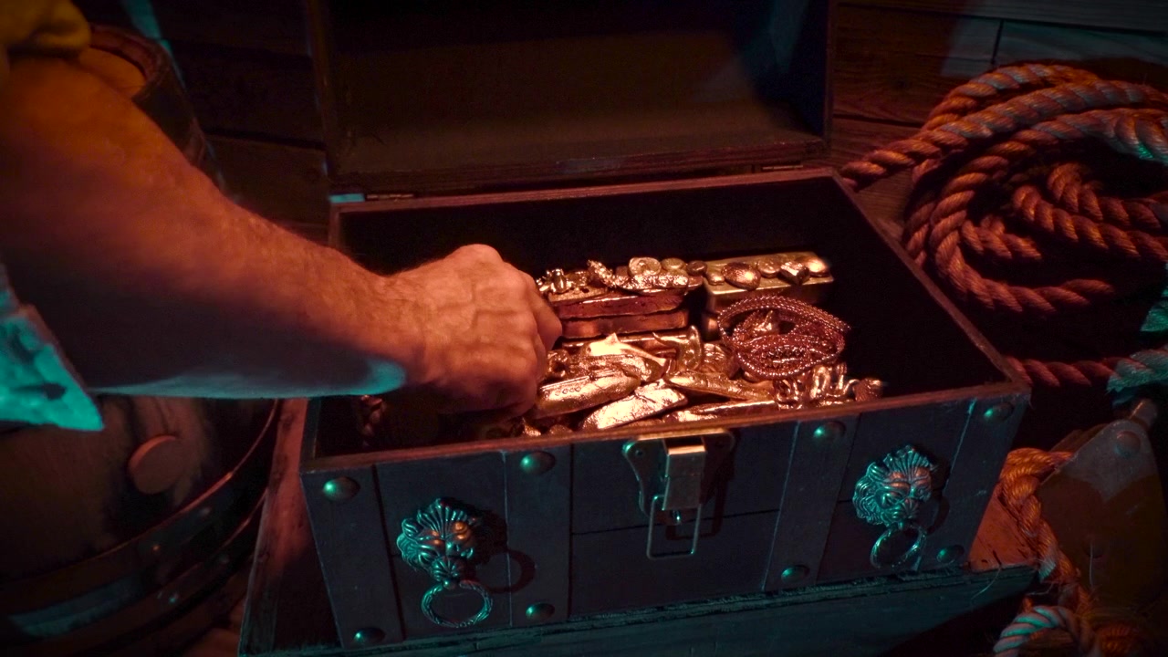 Un lingote de disco de oro es sacado de un cofre del tesoro.