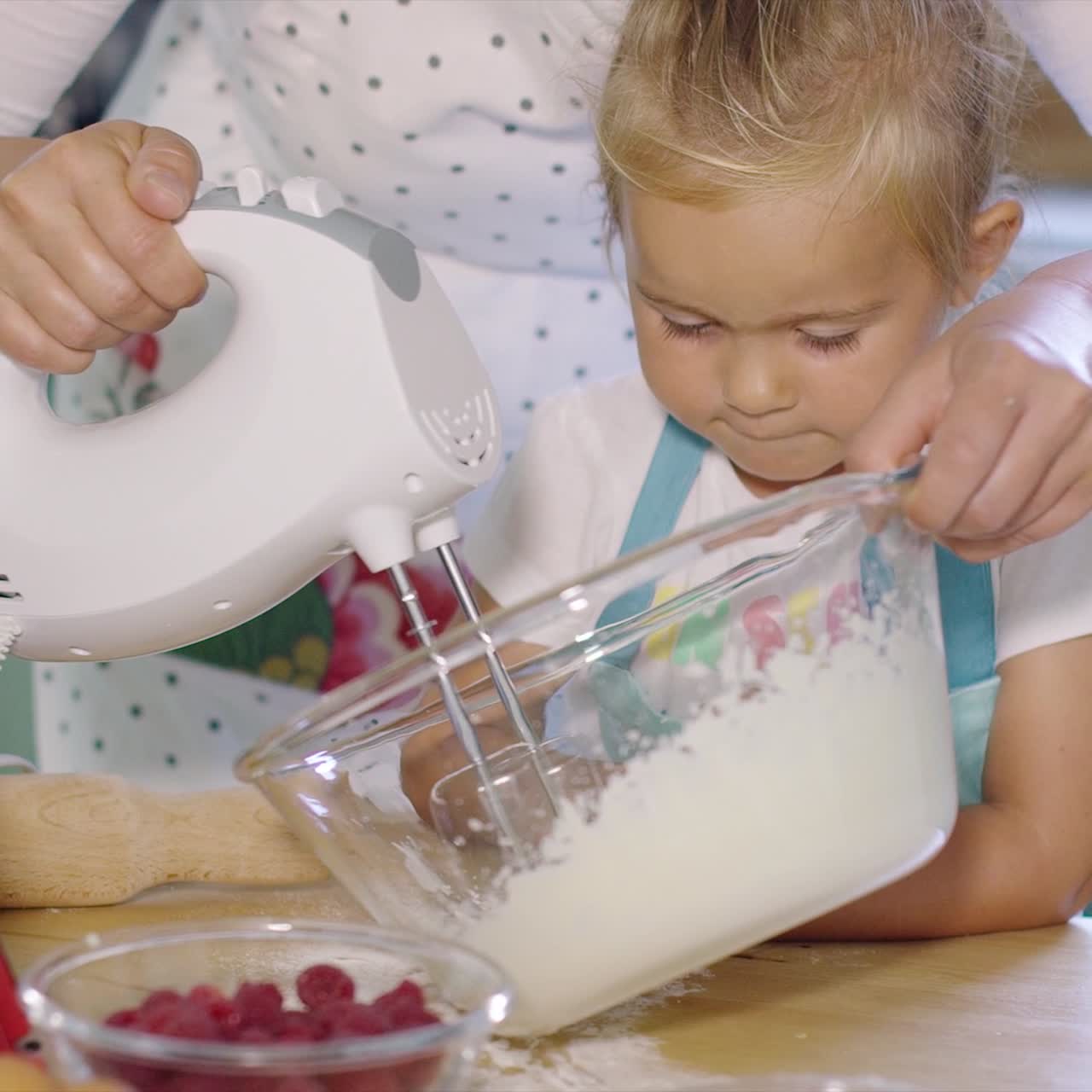 niña viendo a su madre batir crema