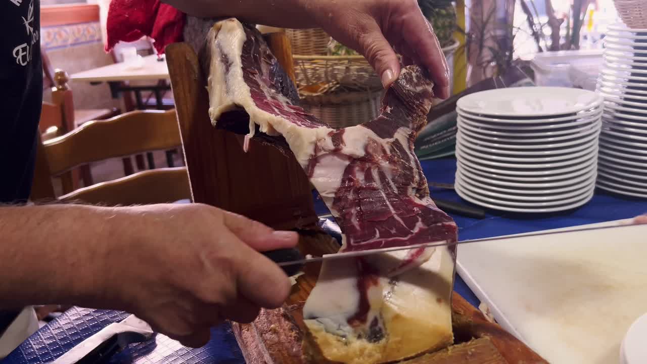 한 사람이 고기를 작은 조각으로 잘라서 요리 예술을 만니다.