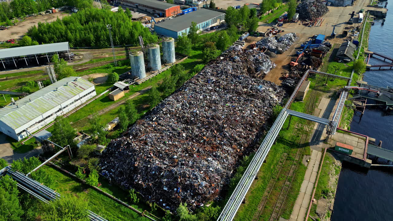 Piles of old recycled metal stored and ready for export, aerial orbit view