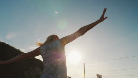 a woman dances on a yacht against the backdrop of the setting sun 1