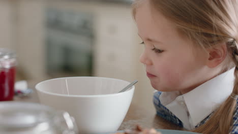 beautiful little girl eating breakfast cereal in kitchen father preparing daughter for school in morning