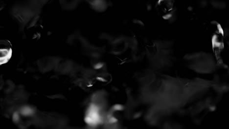 splashes and drops on the surface of the liquid. abstract black background water vibration. 4k slow motion 100 fps, prores 422, 10 bit