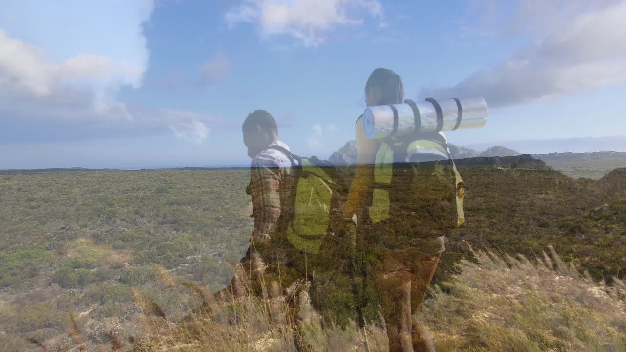 two hikers hiking on grassy hill overlooking scrubland, displaying animated travel route map