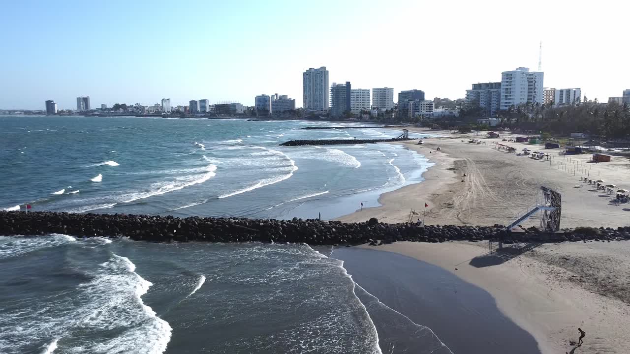 The skyline of Boca del Río, Veracruz, seen from above the sea, with waves breaking softly along the shore