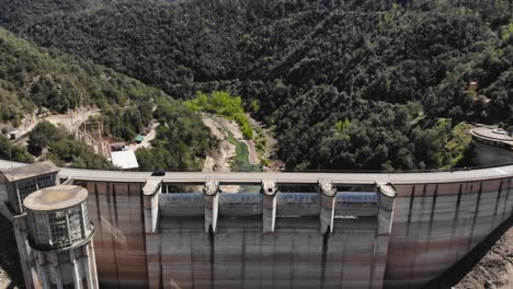 damm with empty reservoir and a car crossing over the damm