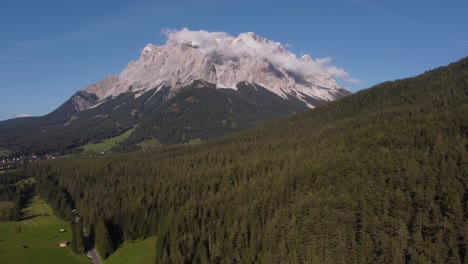 descending drone shot of the spectacular matterhorn filmed on a sunny day with a drone until the mountain is covered with trees in the foreground