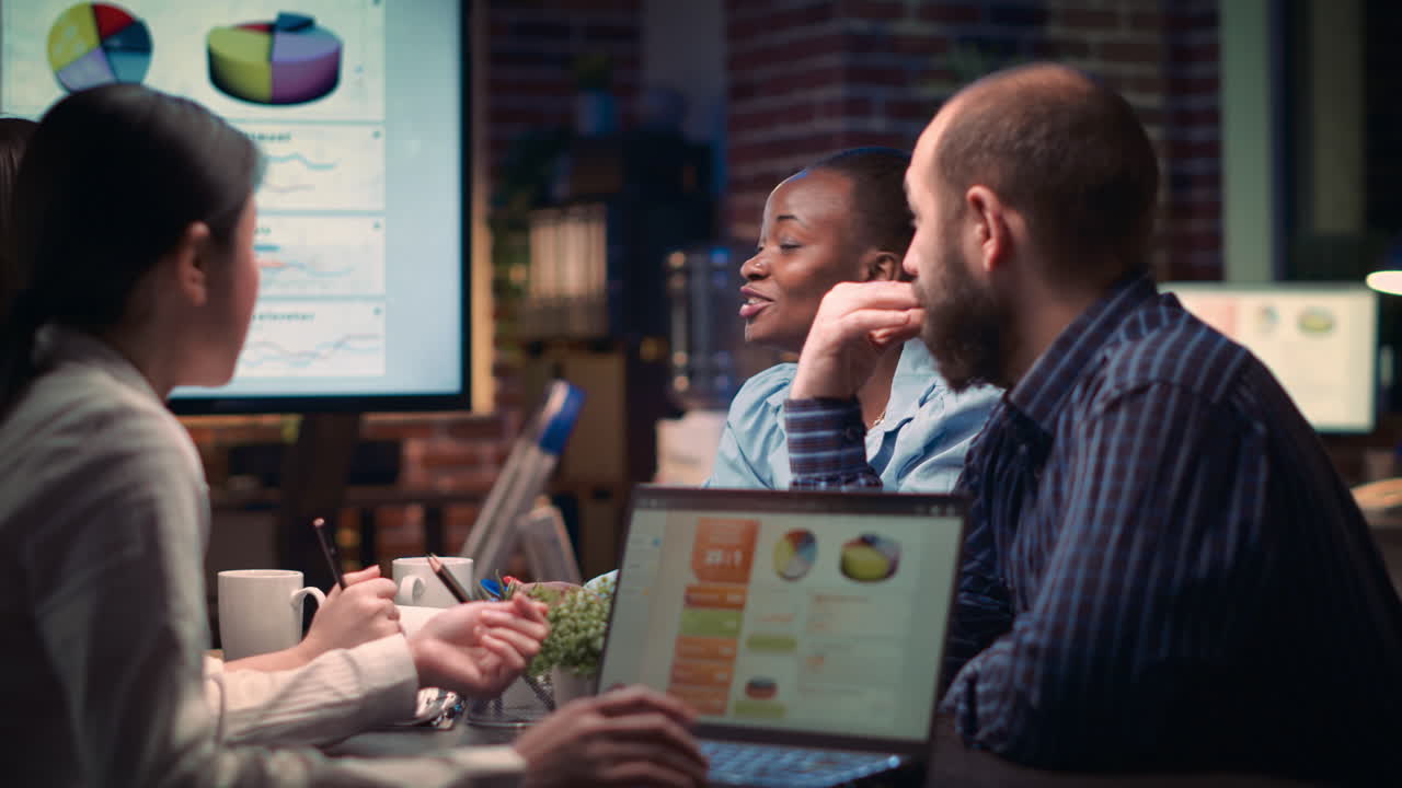 Coworkers discussing revenue statistics presentation in business meeting
