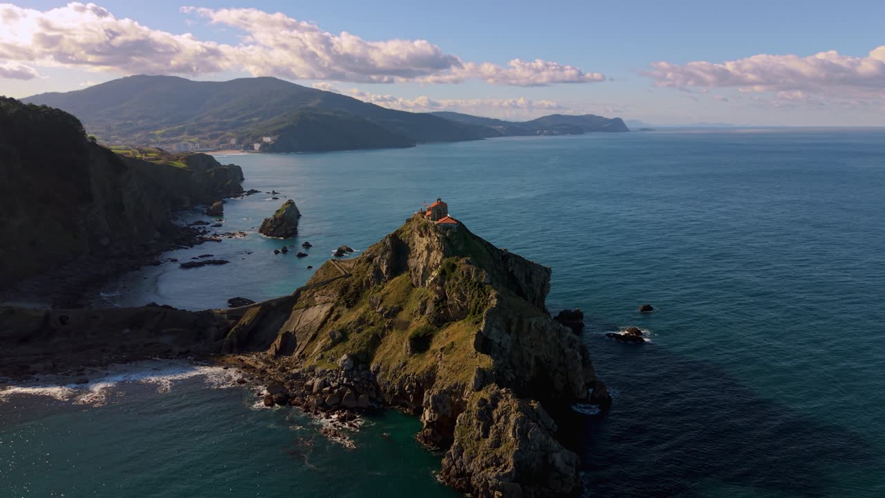 Chiesa sull'isola rocciosa di San Juan de Gaztelugatxe con gradini in pietra e costa basca circostante, Spagna, vista aerea