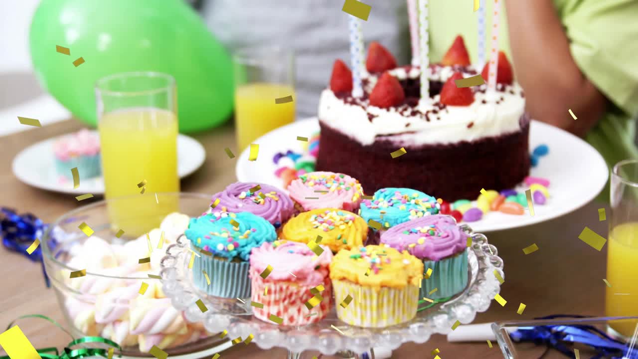 Camera opening focusing on cupcakes while confetti drifting then revealing tiered celebratory cake