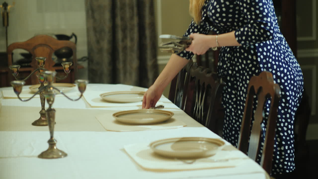 한 여자가 가정 식당에서 테이블을 제공합니다