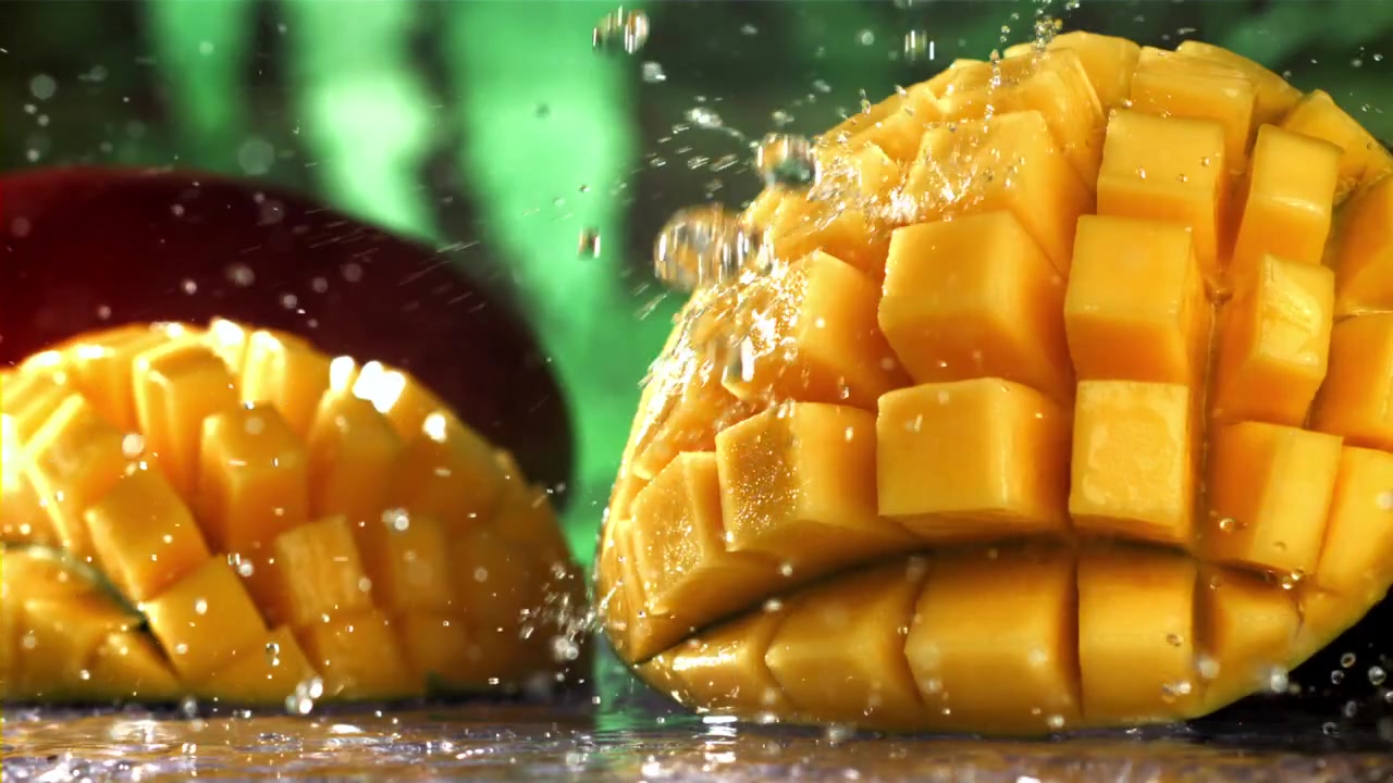 Świeżo pokrojone mango chlapiące wodą w zwolnionym tempie