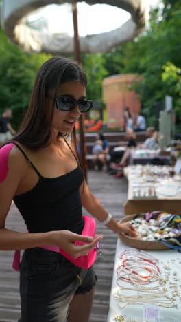 young woman shopping for jewelry at a market