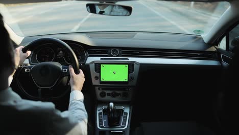 vista trasera de un hombre de negocios casual clásico con camisa blanca usando un reloj inteligente en sus manos mientras conduce un coche con una maqueta de pantalla verde. aplicación de menú de servicio de tablero de instrumentos. navegación. mapa. conductor