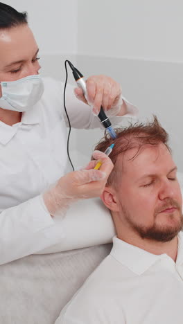 trichologist doing man improve hair growth procedure dermapen microneedling vitamin injections