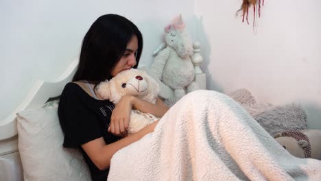 depressed girl on bed with her teddy bear