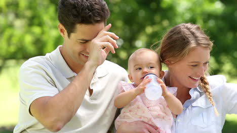 padres felices con su niña en el parque