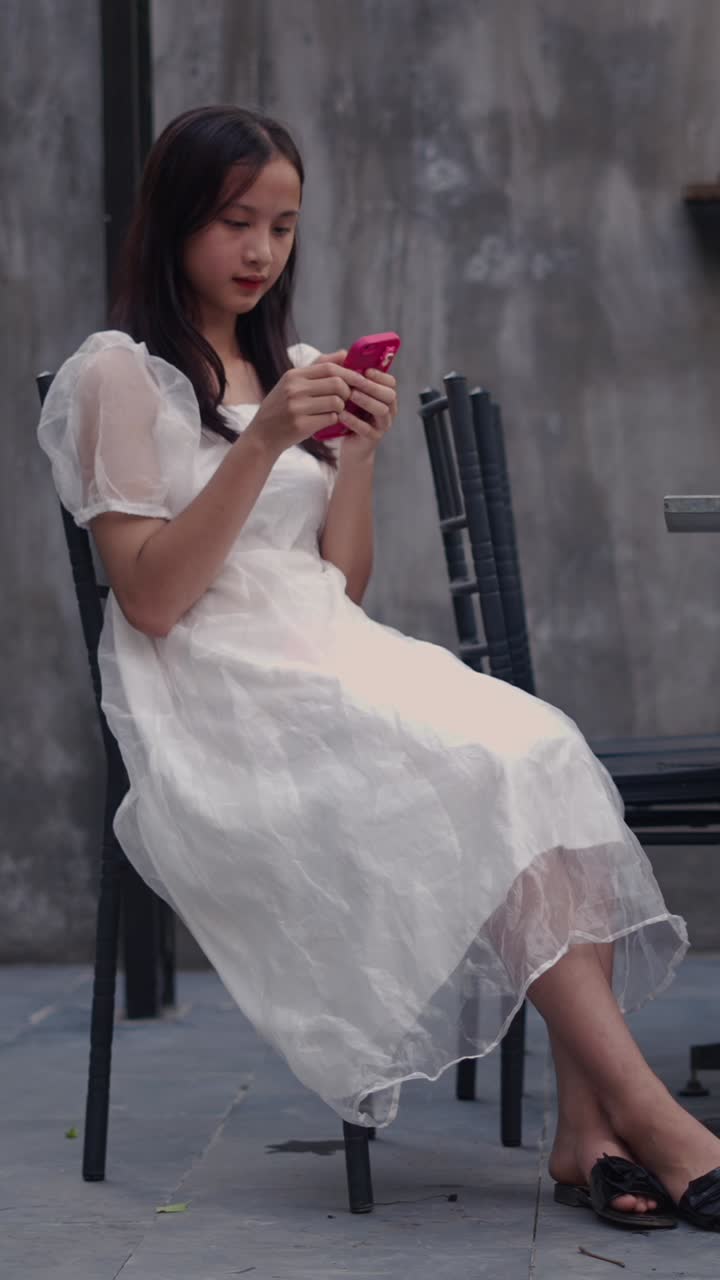 Woman in white dress using cell phone