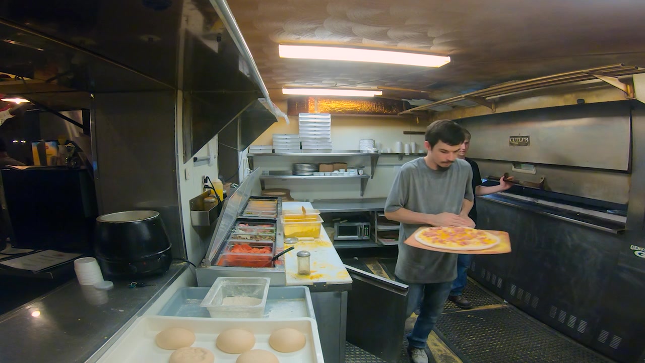 Le personnel de cuisine préparant des pizzas dans la cuisine d'une pizzeria familiale
