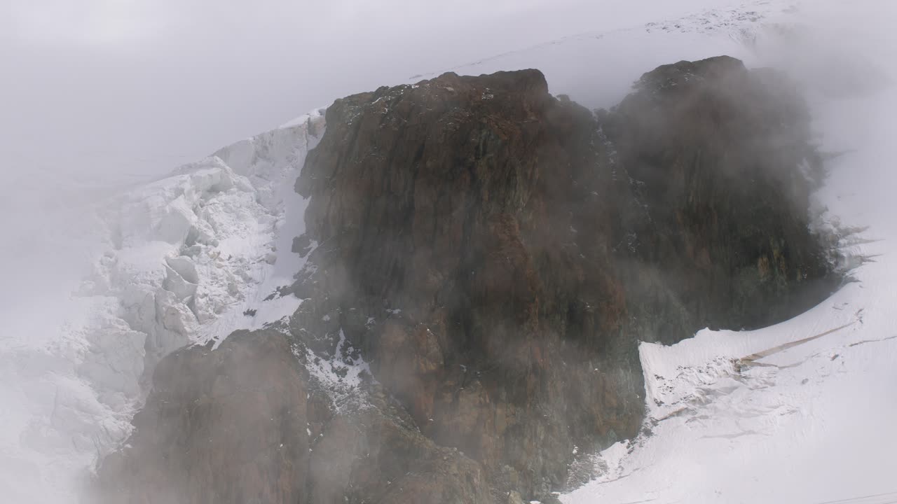 Vue brumeuse sur les Alpes à Cervinia, en Italie, mettant en valeur des pics enneigés et accidentés