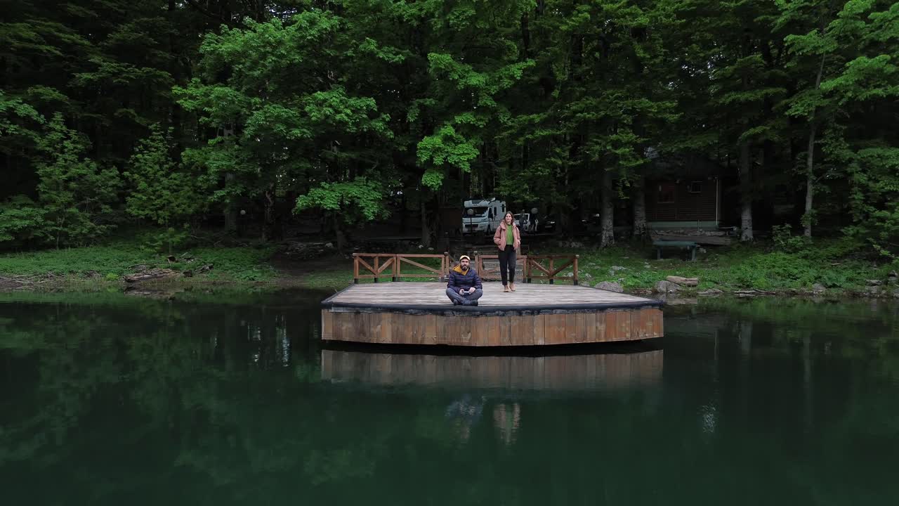 Tourist sightseeing at Lake Biograd in Biogradska Gora National Park in summer, Aerial pullback shot