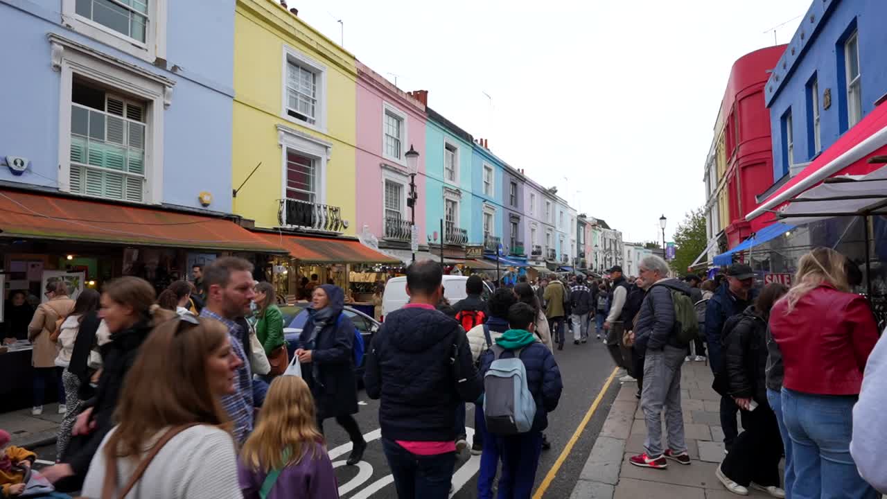 Crowded Portobello Road market on cloudy day, Notting Hill, London. Handheld