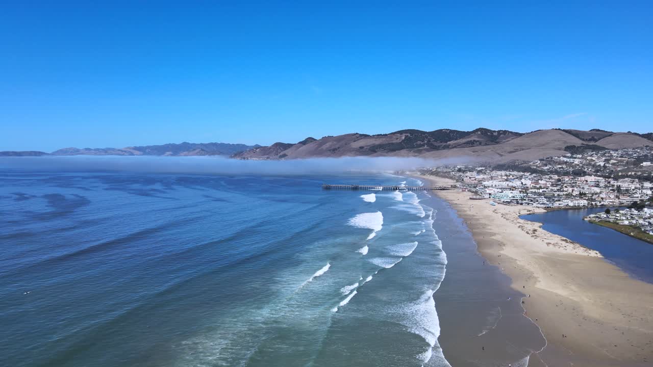 pismo 해변 위를 날아다니며, 놀라운 바다 전망과 뒷면의 웅장한 산을 포착합니다. 이 환상적인 항공 드론 영상으로