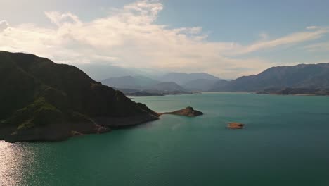 aerial rotating shot of a tropical lake with large mountains surrounding in mendoza