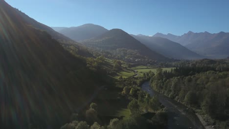Río-Que-Fluye-En-El-Valle-Verde-Durante-La-Temporada-De-Verano-Con-Montañas-En-El-Fondo,-Pirineos-Franceses