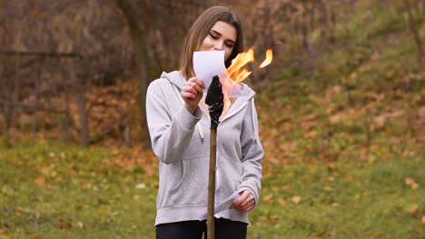 beautiful vocalist woman singing and burning photos with torch