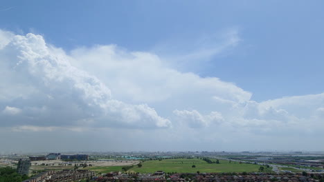 Time-lapse-of-moving-dense-white-clouds-in-sky-and-busy-town-life-underneath