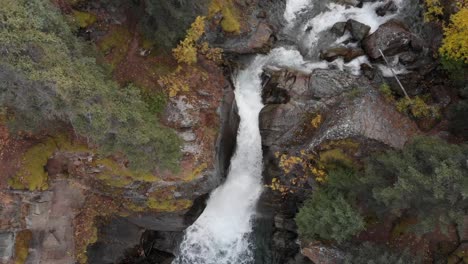 Scenic-Cascading-Waterfall-Crashes-Through-Rocky-Mountain-Surrounded-By-Pine-Trees-In-Alaska