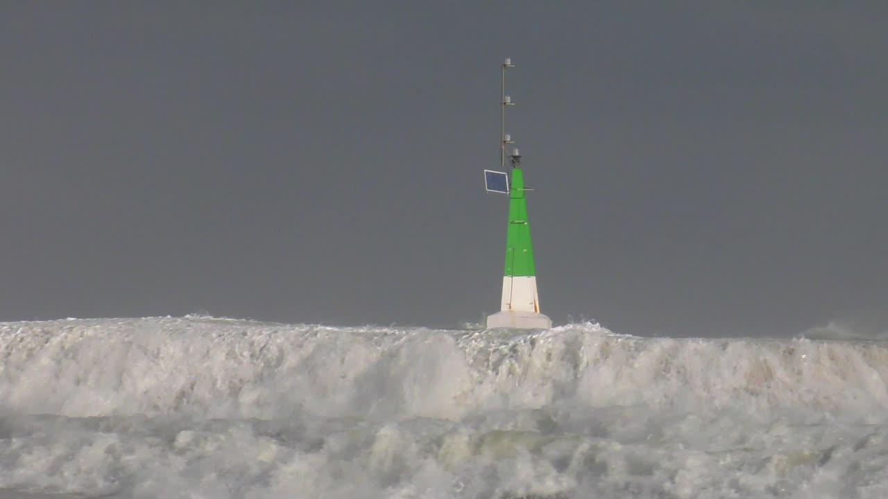 Big waves breaking over harbour wall in stormy weather