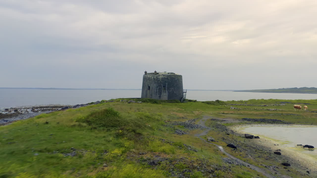 Dynamic aerial approaches Aughinish Martello Tower facing Galway Bay on Ireland's west coast