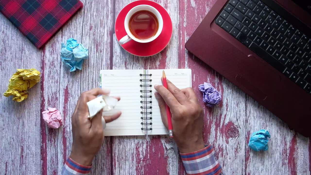 persona que trabaja en un escritorio con un cuaderno y una computadora portátil