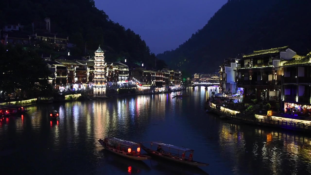 Vista noturna da Cidade Antiga de Fenghuang na Província de Hunan, China, destacando seu encanto histórico com arquitetura chinesa tradicional, casas sobre palafitas, ruas de paralelepípedos e paisagens ribeirinhas.