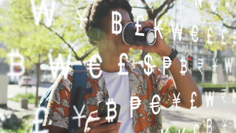 animación de símbolos de moneda, hombre afroamericano con auriculares usando teléfono y bebiendo café