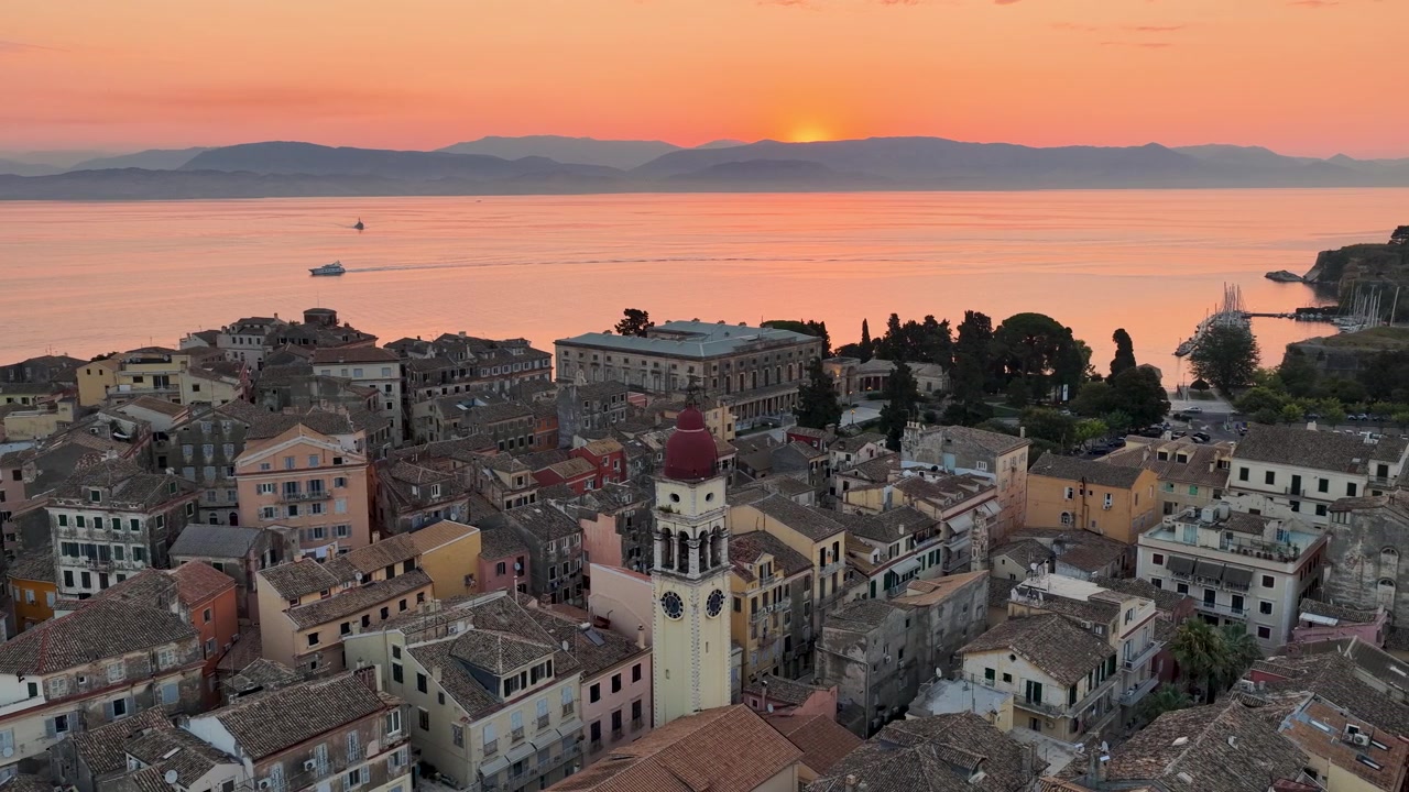 Vista Aérea del Casco Antiguo de Corfú al Amanecer, Grecia: Arquitectura Veneciana Histórica, Reloj de la Torre de la Iglesia de San Espiridón, Cielo Naranja de la Hora Dorada y Mar en Calma