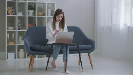 La-Mujer-Trabaja-Remotamente-Por-Internet.-Una-Joven-Y-Feliz-Mujer-De-Negocios-Usa-Auriculares-Y-Habla-Con-Una-Cámara-Web-Haciendo-Una-Videoconferencia-En-Línea-A-Distancia.-Profesora-De-Internet-Haciendo-Trabajo-De-Chat-A-Distancia