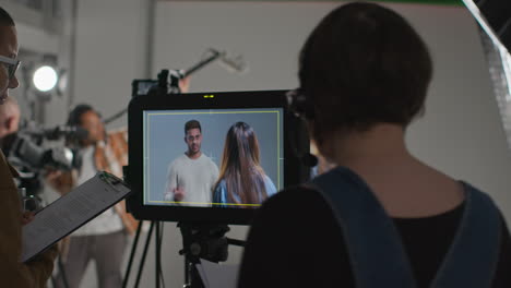 directora de cine y asistente viendo a los actores rodando una película o un video en el estudio en el monitor 5