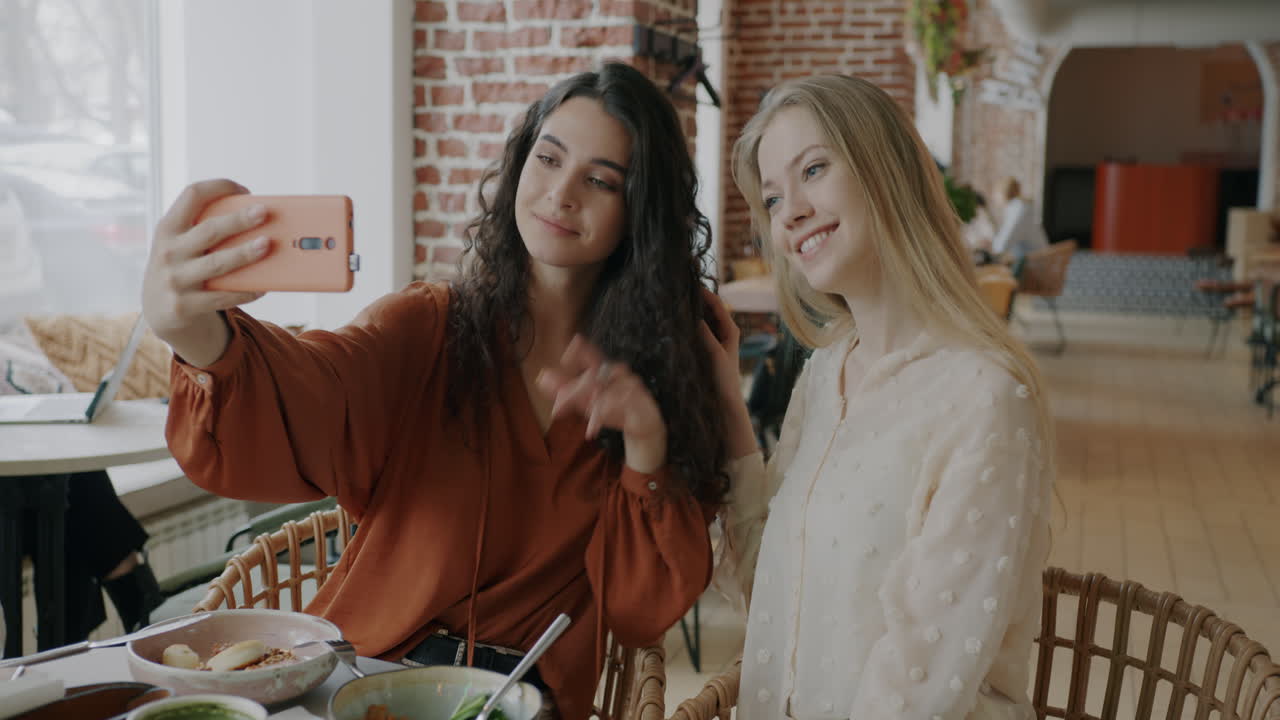 dos amigos tomando una selfie en un café