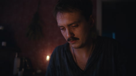 man examining a mysterious jar by candlelight