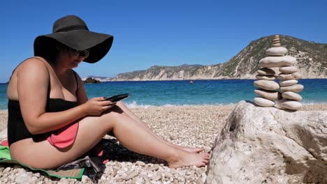 playa escénica de agia eleni en grecia con mujer relajándose en la orilla - tiro estático